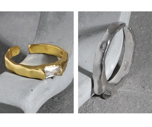 Detail of S925 sterling silver hammered rings with rectangular zircon in gold and silver
