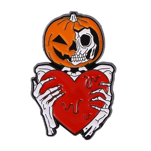 Detail of Halloween enamel pin featuring a skeleton holding a red heart inside a pumpkin