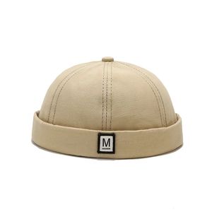 Light khaki brimless dock hat with M letter fashion patch and top button detail