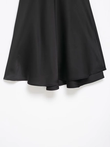 Vue détaillée d'une robe noire à double couche en dentelle avec une texture de satin lisse