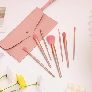Professional 7-piece makeup brush set with soft pink bristles and a matching leather pouch