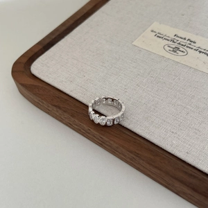 Detailed view of silver S925 heart ring with row diamonds on a luxury jewelry display