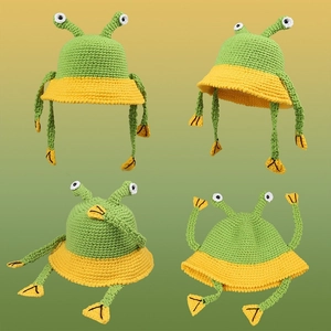 Handmade knitted frog bucket hat in green and yellow with decorative eyes and long frog legs