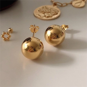Macro shot of minimalist gold ball stud earrings in polished S925 sterling silver