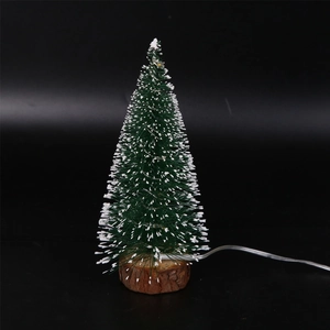 Close-up of a mini snowy cedar tree with LED lights on a natural wooden base