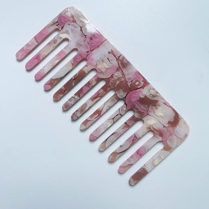 Detail of pink marble pattern on wide-tooth cellulose acetate anti-static hair comb