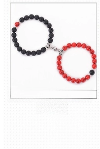 Close-up of magnetic couple bracelets with black volcanic stone and red turquoise beads