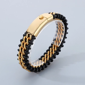 Detail of black braided leather bracelet with gold metal chain links and polished clasp