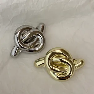 Minimalist knot design hair clips set in gold and silver finish with polished metal texture