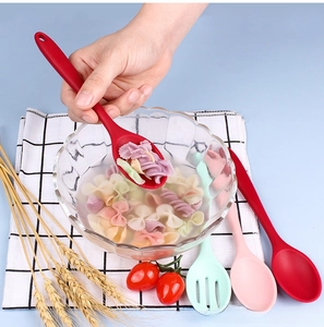 Action shot of silicone slotted spoon lifting pasta, showing heat-resistant kitchen tool