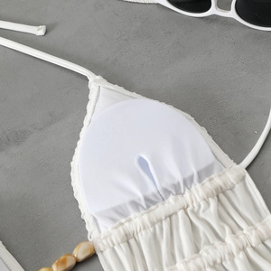 Detail of white bikini top with removable pads and decorative marble beads on strings