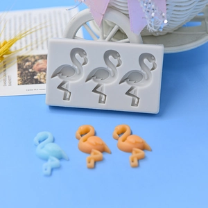 Three-cavity flamingo silicone ice cream mold with finished samples on blue background