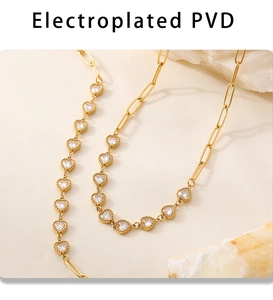 Macro detail of gold PVD plated paperclip chain with sparkling heart zircon crystals