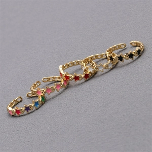 Macro shot of 18K gold plated copper star rings featuring vibrant colorful enamel inlay