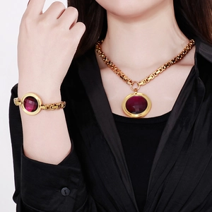 Detailed close-up of golden chain necklace and bracelet with purple round gemstones