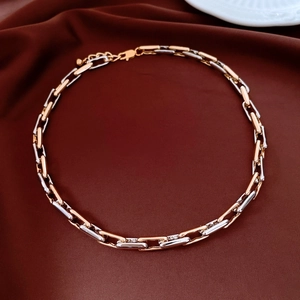 Detail of adjustable gold and silver chain necklace on red velvet luxury background