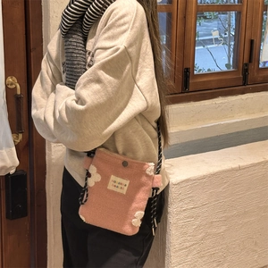 Detail of soft pink plush crossbody bag with white flower patterns and rope strap