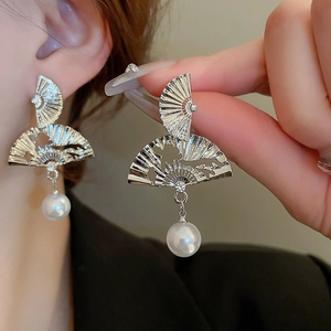 Elegant Chinese fan-shaped silver earrings with pearls worn by a model for a classic look