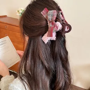 Pink tweed bow claw clip with acrylic base shown on model hair for elegant styling