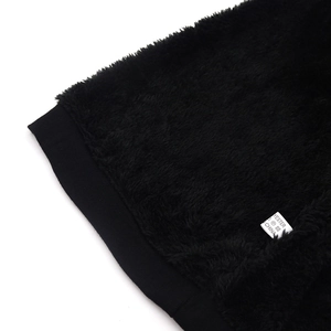 Detail of warm black fleece lining and polyester material label on a winter beanie hat