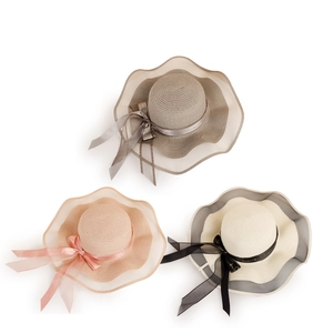 Three wide brim straw hats with ribbon bows in taupe, beige, and cream colors