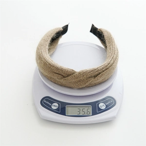 Detailed view of beige knitted knot headband weighing 35.6g on a digital scale