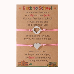 Dettaglio dei braccialetti rosa con cuore su biglietto Back to School per madre e figlia