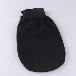 Detail of black exfoliating glove with elastic wristband and hanging loop texture