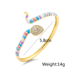 Detail view of gold snake cuff bracelet with colorful enamel and zircon stones