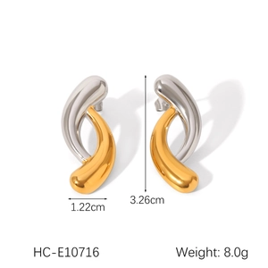 Detailed view of two-tone twisted earrings with gold and silver finish on white background