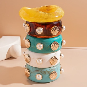 Set of five vintage resin bangle bracelets with faux pearls and gold shell accents