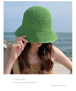 Detail of green handmade straw hat with hollow crochet knit pattern for summer beach wear