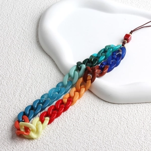 Close-up of colorful acrylic chain links and brown lanyard on a textured surface