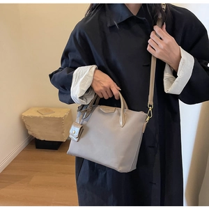 Detail of taupe oxford cloth bucket bag featuring detachable strap and mini coin purse