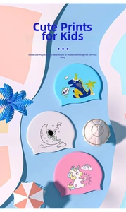 Detailed view of three silicone kids swimming caps with unicorn, astronaut, and dinosaur prints