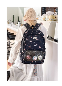 Detail of dachshund print backpack featuring a clear PVC window and decorative badges