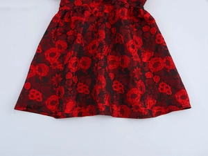 Close-up of red and black floral jacquard fabric on an A-line mini skirt texture