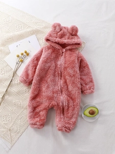Pink plush baby romper with bear ears hood on white fabric, winter warm fleece jumpsuit