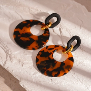 Detail of tortoiseshell resin hoop earrings with gold links and black oval accents