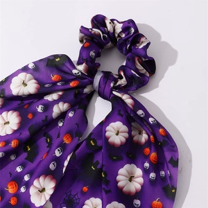 Détail d'un chouchou en satin violet avec motifs d'Halloween de citrouilles et chauves-souris