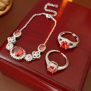 Macro detail of red gemstone bracelet and ring set on an elegant wooden jewelry box