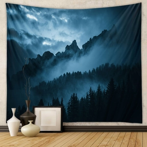 Detail of bohemian tapestry featuring a deep blue misty forest and mountain landscape