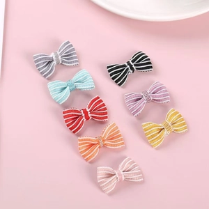 Close-up of eight colorful striped fabric bows for DIY plush toys and hair accessories