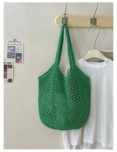 Close-up of green crochet tote bag showing hollow knit texture and woven shoulder strap
