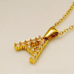 Macro shot of gold-plated letter A pendant with clear cubic zirconia on link chain