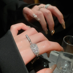 Macro shot of silver plated bow ring with sparkling zircons worn by model in dim light