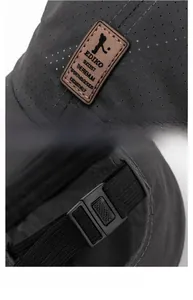 Detail of dark grey baseball cap with mesh texture, leather logo, and adjustable buckle