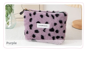 Detail of purple faux fur makeup bag with black leopard spots and zipper closure