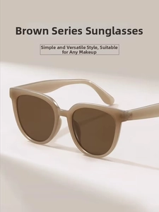 Detail of oval tea-colored sunglasses with a translucent matte frame on a beige background
