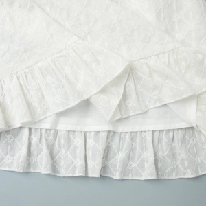 Détail de l'ourlet à volants blancs à double couche avec broderie évidée